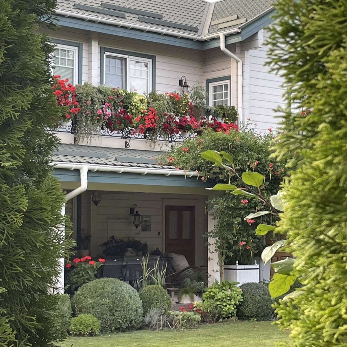 Home exterior with a flower-covered upper balcony and covered front porch