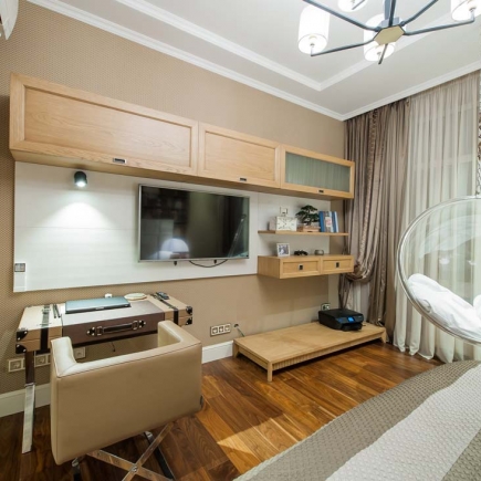 Bedroom desk nook with floating shelving and a hanging bubble chair beside the bed