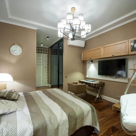 Bedroom with built-in media wall, desk nook, and wall-mounted air conditioner
