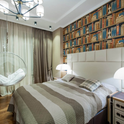 Bedroom with library-print wallpaper headboard wall and a hanging bubble chair