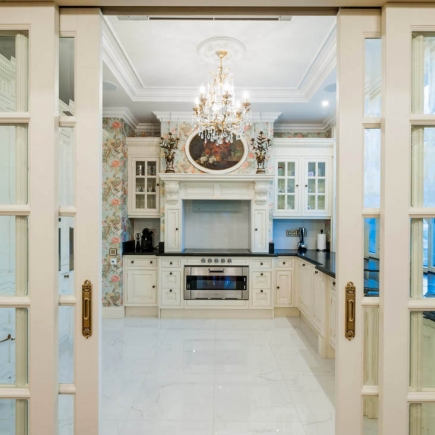 Kitchen entrance framed by mirrored French pocket doors with brass hardware