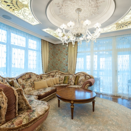 Living room seating area with floral upholstered sectional and round coffee table
