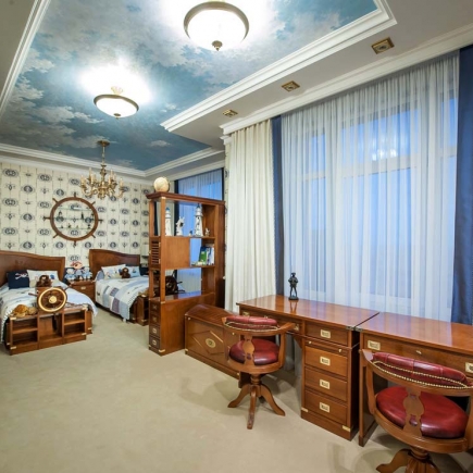 Nautical-themed twin bedroom with a painted sky ceiling and ship's-wheel wall clock
