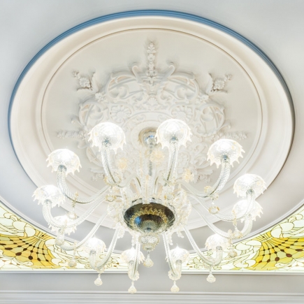 Overhead view of a carved plaster ceiling medallion with a Murano glass chandelier