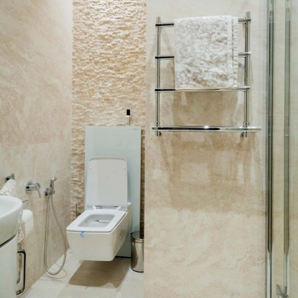 Powder room with a wall-mounted toilet, bidet, and stone-textured accent wall