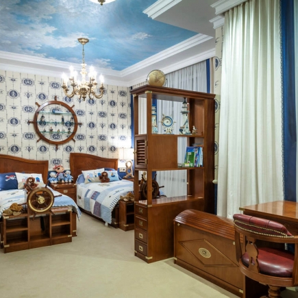 Twin nautical bedroom with a display cabinet, storage trunk, and desk chair