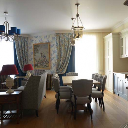 Elegant dining room with classic wooden table, upholstered chairs, crystal chandelier
