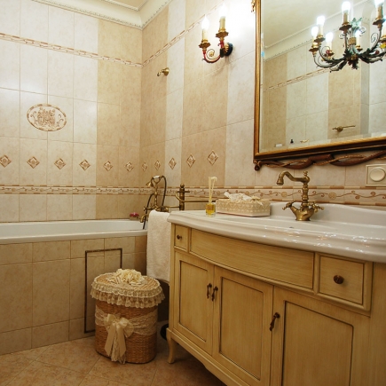 Bathroom wall detail with a framed seascape painting and a brass towel ring