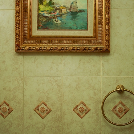 Bathroom with a tub, a timber vanity with a brass faucet and wall sconces