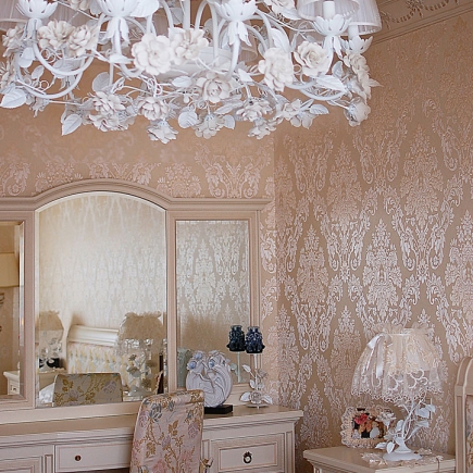 Lace-covered side table with a porcelain figurine beside a floral armchair