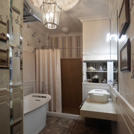 Bathroom with a pendant lantern, freestanding tub, curtained shower, and marble vessel sink