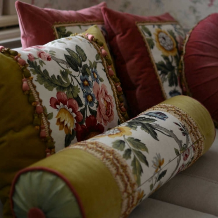 Close-up of floral and burgundy velvet throw pillows on the sofa