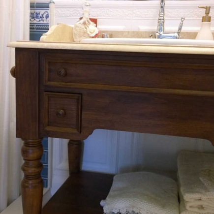 Close-up of the marble-topped bathroom vanity with wood drawers