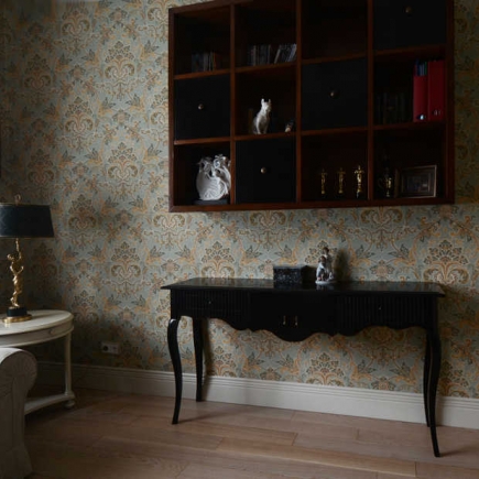 Console table beneath a wall-mounted curio shelf in the damask-papered nook