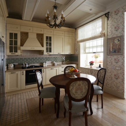 Kitchen dining nook with a wrought iron chandelier, round table, and floral wallpaper
