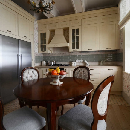 Kitchen dining table with a bowl of fresh fruit beneath tufted floral chairs