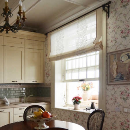 Kitchen window seat with a Roman shade, floral wallpaper, and a bowl of fresh fruit