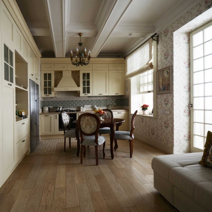 Kitchen with cream cabinetry, a round dining table, and floral wallpaper beneath a coffered ceiling