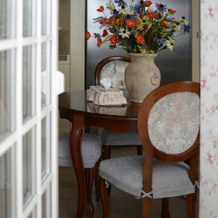 Powder room with floral wallpaper, a freestanding tub, glass shower, and marble-topped vanity