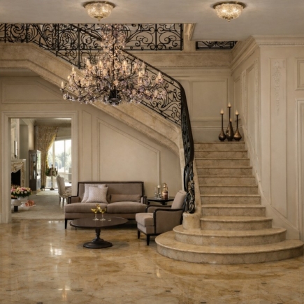 Curved staircase with wrought-iron balustrade and crystal chandelier above a marble-floored sitting area