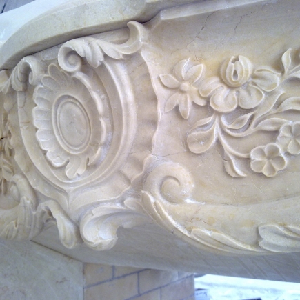 Detail of hand-carved floral and scroll relief on the fireplace mantel
