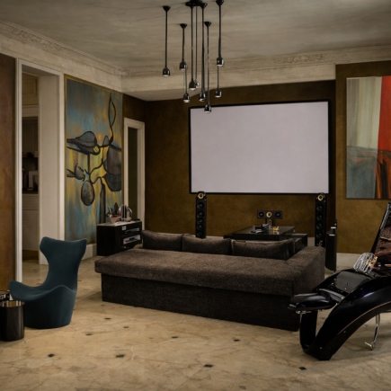 Home theater with tiered seating, projector screen, and gallery-style wall art