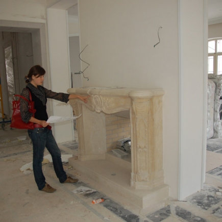 Team member reviewing the carved marble fireplace mantel during installation