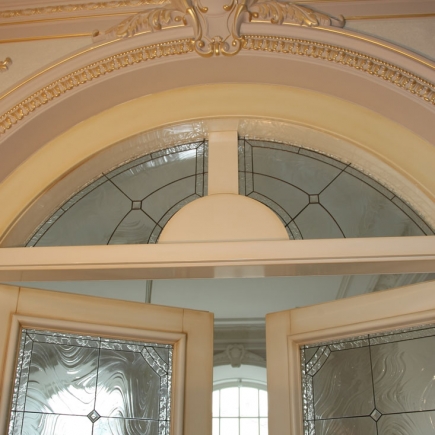 Arched stained-glass transom above the entry doors