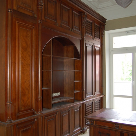 Carved mahogany built-in bookcase with an arched display niche
