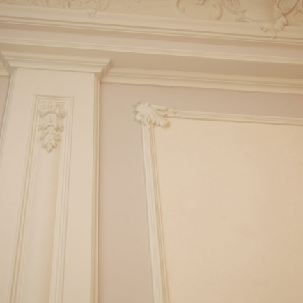 Corner detail of the carved boiserie panel and cornice moldings