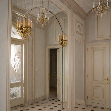 Mirrored hallway with gilt bronze sconces and checkerboard marble floor