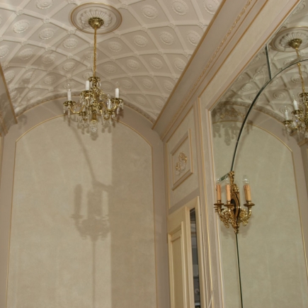 Vaulted ceiling with a gilt crystal chandelier and mirrored reflection