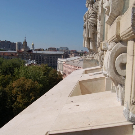 View from the rooftop terrace past classical stone statuary over the city skyline