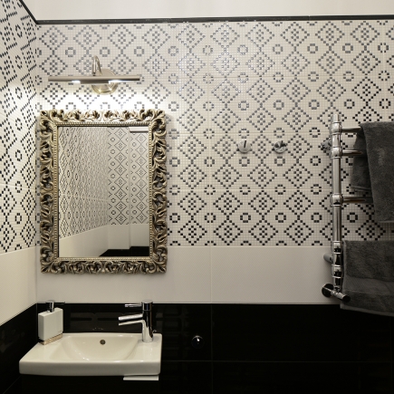 Bathroom with a mosaic-tiled accent wall, gilt-framed mirror, and vessel sink