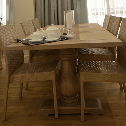 Close-up of the dining table set with a teapot, cups, and glass candle holder