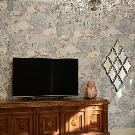 Wall-mounted TV and ceramic vase on the antique sideboard beneath a crystal chandelier