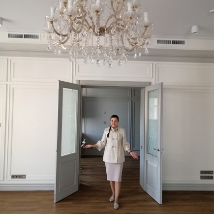 Empty meeting room with classical panelled walls and a chandelier with white shades