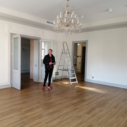 Finishing touches to the office interior — a step ladder beneath the grand crystal chandelier