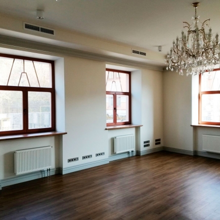 Panelled corner with grey doors opening into a small adjoining room