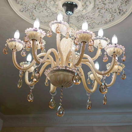 Amber crystal chandelier beneath an ornate ceiling medallion