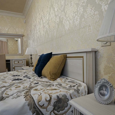 Bedroom headboard detail with navy and mustard velvet pillows against gold damask wallpaper