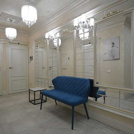 Mirrored entry hallway with a navy velvet bench, crystal sconces, and a ballet-dancer print