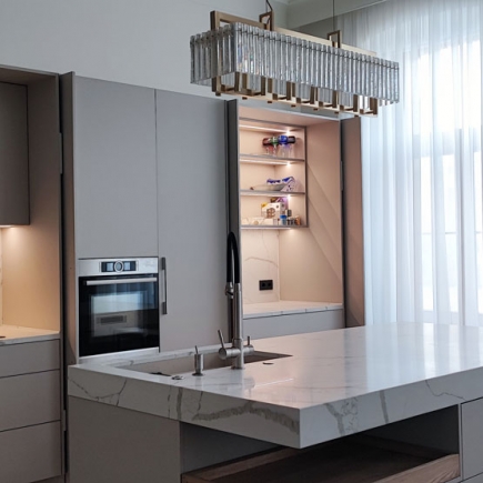 Kitchen wall unit with built-in oven, illuminated pantry cabinet, and crystal pendant chandelier
