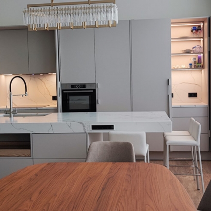 Minimalist kitchen with matte gray cabinetry, marble backsplash, and illuminated open shelving