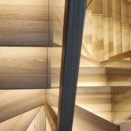 Overhead view of a triangular wood-paneled staircase landing