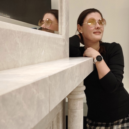 Woman leaning on the marble fireplace mantel