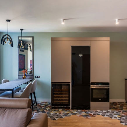 Kitchen area with built-in wine fridge, oven, and mosaic tile floor