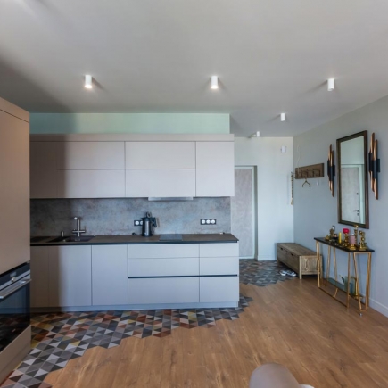 Kitchen with dark countertops, mosaic tile floor, and entryway console beyond
