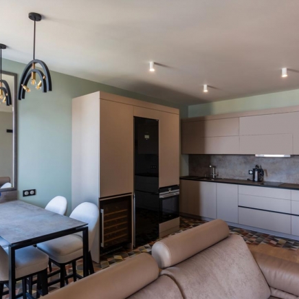 Kitchen with sage green walls, built-in wine fridge, and patterned tile floor