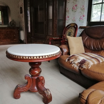 Antique marble-top table beside a leather sofa in the sitting room